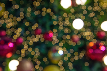 Illuminated  blurred bokeh of  Christmas tree decoration with  hanging lights ball. © Pataradon