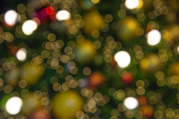 Illuminated  blurred bokeh of  Christmas tree decoration with  hanging lights ball. © Pataradon