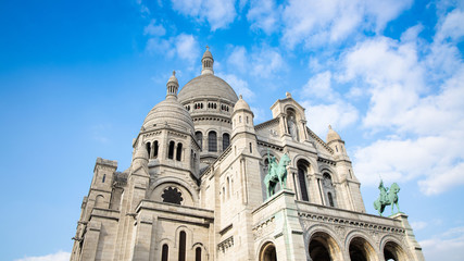 Fototapeta na wymiar Basilica of the Sacre Couer on Montmartre with blue sky and clouds , Paris, France. Catholic church cathedral is popular in Europe