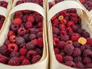 Ripe, sweet raspberries in a wicker basket. Basket with berries sold in the market