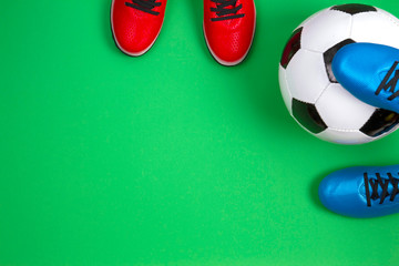 Soccer football sport background. Top view to soccer ball and boots on green background