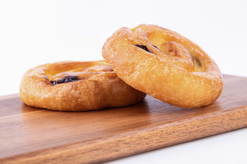 A couple of rolls of puff pastry with honey on top on a cutting board