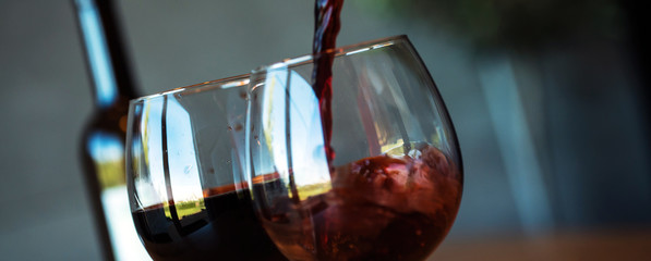 Pouring red wine on a wooden oak table