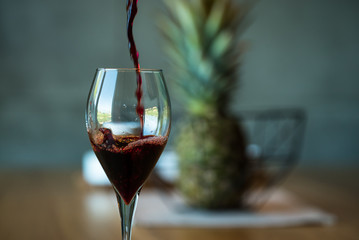 Pouring red wine on a wooden oak table