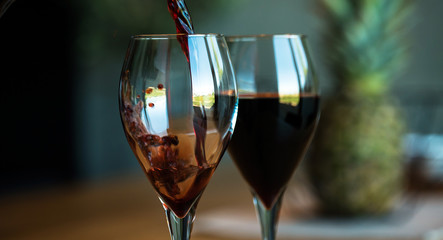 Pouring red wine on a wooden oak table