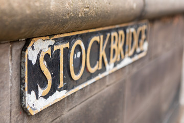 weathered street sign for the Stockbridge neighborhood with golden letters