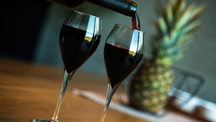 Pouring red wine on a wooden oak table