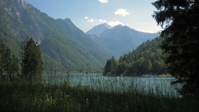 Grass Clearing In Front Of Mountain Lake Surrounded By Mountains Push In Shot, Lago Del Predil, Italy