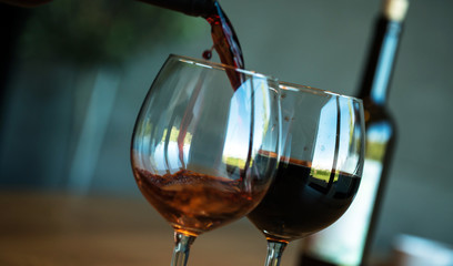 Pouring red wine on a wooden oak table