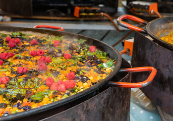 paella is cooking in a a big gas cooker and steam is bubbling