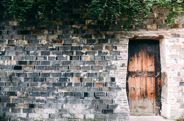 Background of The old brick walls stacked in layers with copy space and wooden door or Can use wallpaper.