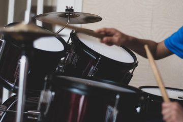 Child's drum set with visible drumsticks and hands. 