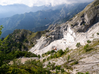 Fototapeta na wymiar PASSO DEL VESTITO, MASSA CARRARA, ITALY - JULY 5, 2019: Stunning view looking down over white marble quarry, high up in the Apuan Alps, Alpi Apuane, Italy.