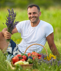 Farmer sitting in the grass with a basket of vegetables