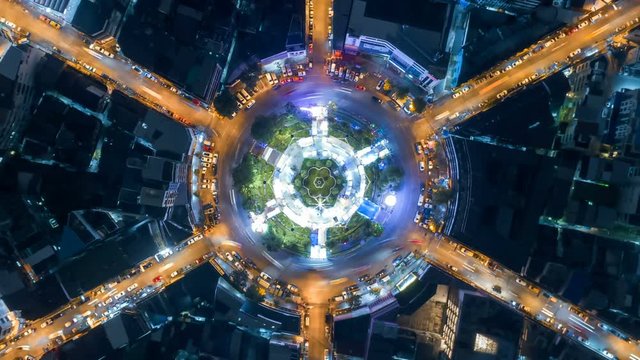 aerial top view traffic circle road roundabout multi 6 lanes in bangkok city at night, Time lapse top road in thailand, zoom out.