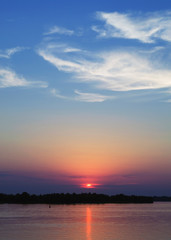 Obraz premium Blazing sunset over the evening river. Flaming sky - the landscape in the setting sun. Amazing colorful sunset over river Dnieper. 