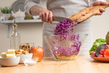 The cook mixes purple cabbage for salad, the concept of tasty and healthy food, diet, vegetarian...