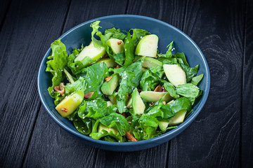 View from above on fresh, homemade vegan bowl. vegetarian salad spinach and avocado in blue bowl on dark wooden background. Copy space. vegan lunch. healthy and balanced food