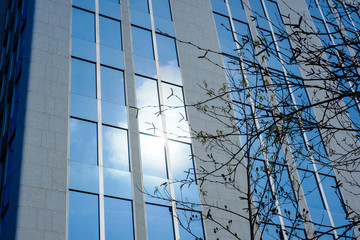 Low angle view of modern business buildings in city against blue clear sky