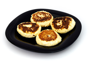homemade cheesecakes, close-up on a black plate on a white background.