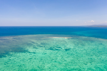 Sandbar on a coral reef. Atoll with a small sandy island. Seascape in the Philippines, view from above.
