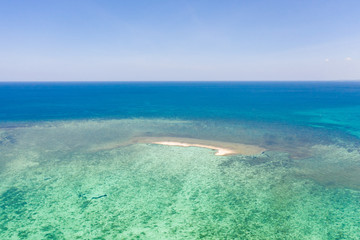 Sandbar on a coral reef. Atoll with a small sandy island. Seascape in the Philippines, view from above.