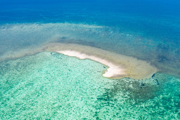 Sandbar on a coral reef. Atoll with a small sandy island. Seascape in the Philippines, view from above.
