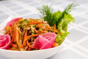 salad of pork ears, carrots, Bulgarian pepper, fresh cucumbers, lettuce, onions and greens seasoned with vegetable oil