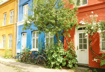 Fototapeta na wymiar Street, Copenhagen, Denmark. Facade old, painted, colorful house. The bikes is parked on the pavement.