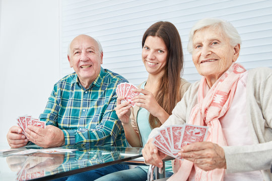 Girl plays cards with seniors couple