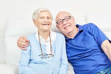 Senior couple happily smiling on the sofa