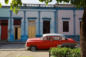 Bayamo, Cuba - July 17, 2018: Old vintage american car with old house in background in Cuba