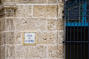 Havana, Cuba - July 29, 2018: A wall with the name of the place. On the right, a blue grating.