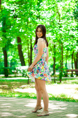 Young beautiful woman in dress in the summer park