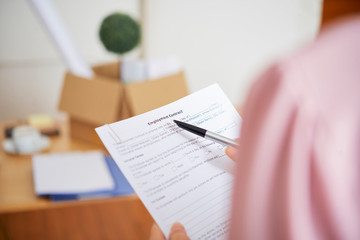 Close-up image of businesswoman reading employment contract and checking details