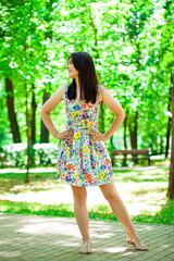 Young beautiful woman in dress in the summer park