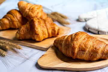 freshly baked croissants on wooden cutting board, top view