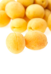 fresh yellow apricots against white background