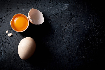 Organic chicken eggs on dark wooden background with copy space. - obrazy, fototapety, plakaty