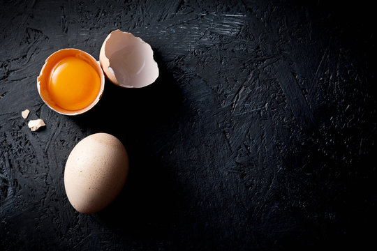 Organic chicken eggs on dark wooden background with copy space.