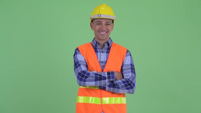 Happy multi ethnic man construction worker smiling with arms crossed