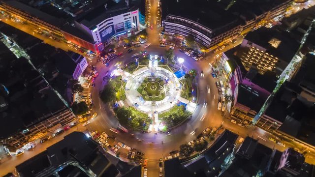 Hyperlapse timelapse of night city traffic on 4-way stop street intersection circle roundabout in bangkok, thailand. 4K UHD horizontal aerial view.