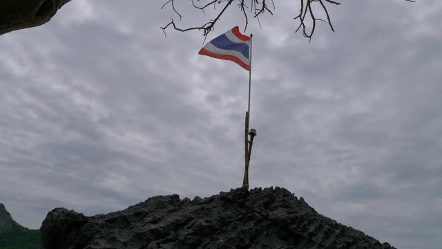 Thai flag fluttering on the rock, Thailand.