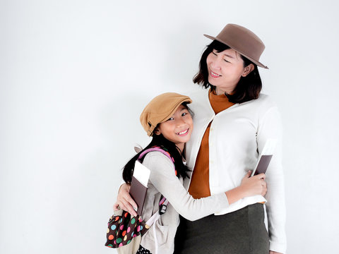 Happy Asian mother and her daughter holding passport, travel concept.