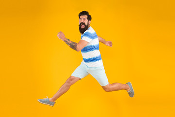 Summer style. Sale and discount. Hurry up. Summer vacation. Man bearded hipster with mustache long beard running yellow background. Guy dressed striped shirt on summer vacation. Barbershop concept