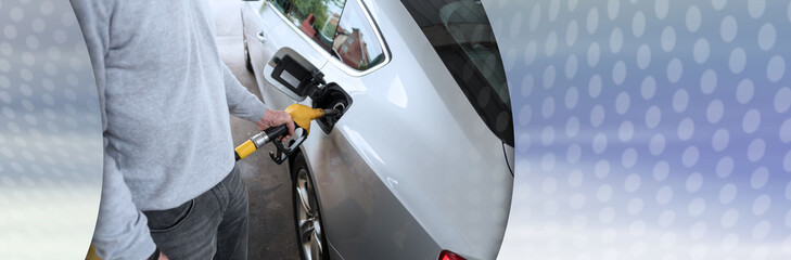 Man holding fuel pump nozzle and refilling car; panoramic banner