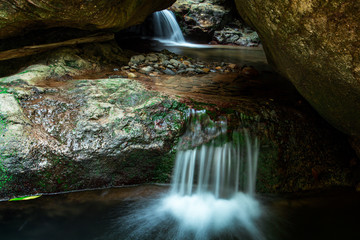Naklejka na ściany i meble Waterfall flow through cavern