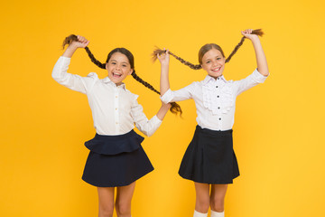 Naklejka premium Schoolgirls formal style perfect school uniform. Happy childhood. School moments. Kids cute students. Education is not only about knowledge. Classmates having fun at school Friends adorable pupils