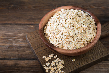 Oatmeal in a wooden bowl on a wooden table