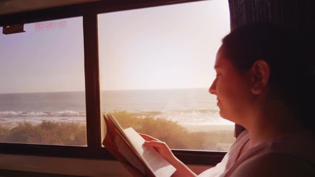 Woman reading a book in the train traveling through California 4K slow motion 60fps